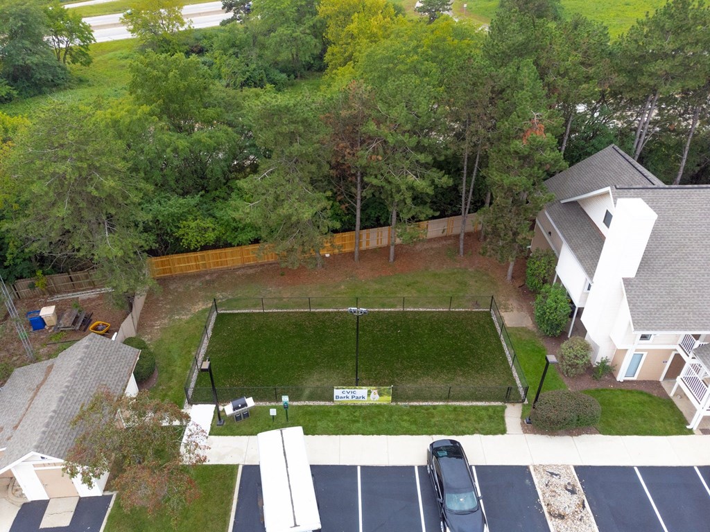 an aerial view of a yard with a tennis court and a house in the background